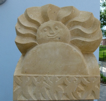 Aus Sandstein gehauene Sonne an der Fassade der Kita Tschaikowskystraße